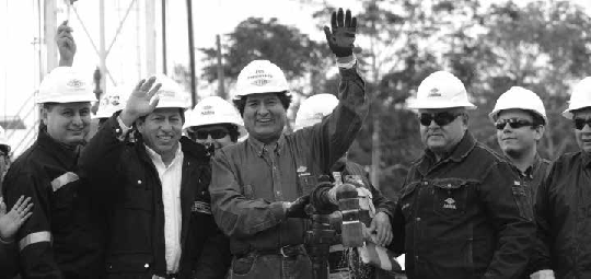 Liturgia del extractivismo petrolero: inauguración de un nuevo campo petrolero, donde el presidente Evo Morales (Bolivia) moja su mano en el crudo, la alza para recibir el aplauso de los asistentes, y luego procederá a bendecir con ella la cabeza de las autoridades que le rodean. Yapacaní,
junio 2015
7

